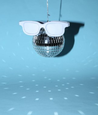 Mavi parlak arka planda gözlüklü disko topu. Minimalizm partisi konsepti