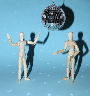 Mavi parlak arka planda disko topunun altında dans eden iki kukla. Minimalizm partisi konsepti