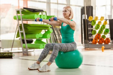 Spor salonundaki spor salonunda spor salonunda spor yaparken halterleriyle spor yapan bir kadın. Sağlıklı yaşam tarzı