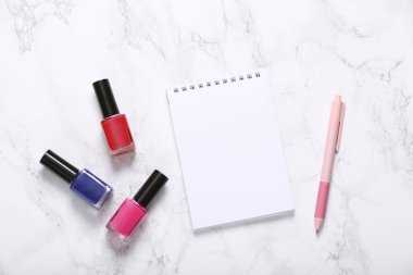 Mermer zemine tırnak cilası ve not defteri.