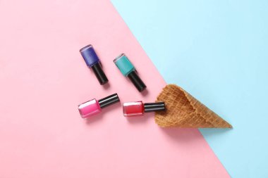 Yaratıcı güzellik düzeni. Pembe arka planda tırnak cilası şişeleri olan gözleme külahı. Düz yatıyordu