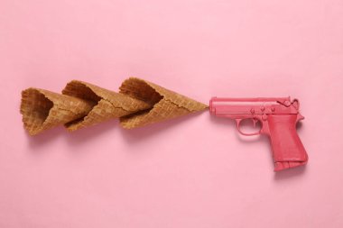 Pembe arka planda dondurma külahlı silah. Minimum parti konsepti. Yaratıcı yerleşim