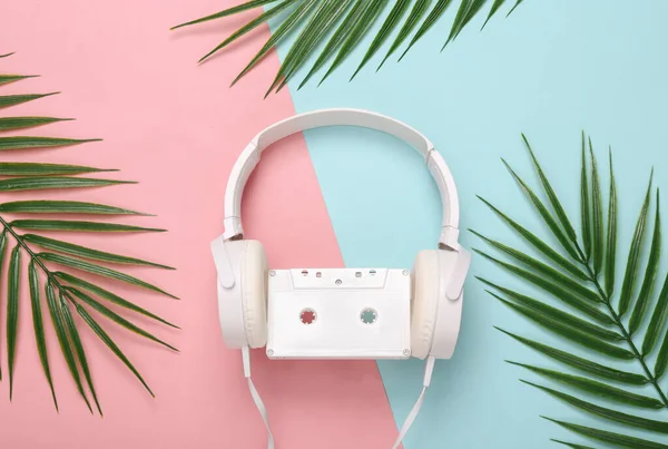 Słuchawki Kasetą Audio Liści Palmowych Różowym Niebieskim Tle Koncepcja Muzyki — Zdjęcie stockowe