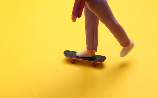 Poppenpootjes Rijden Skateboard Een Gele Achtergrond Minimalisme — Stockfoto