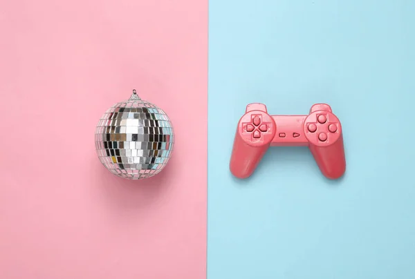 青いピンクの背景にゲームパッドとディスコボール ミニマリストパーティーのコンセプト — ストック写真