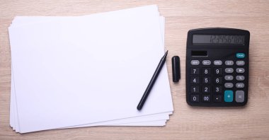 Kağıt çarşaflı ve kalemli siyah klasik hesap makinesi. Üst görünüm