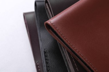 Beyaz arkaplanda deri düzenleyici klasörü ya da çanta yığını