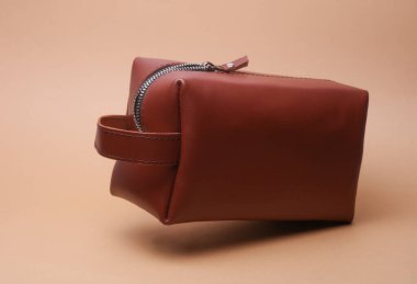 Bej arka planda deri kahverengi kozmetik çanta