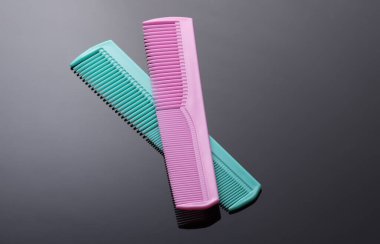 Siyah arkaplanda pembe ve mavi plastik taraklar