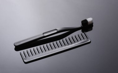 Siyah arkaplanda tarak ve diş fırçası