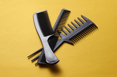 Sarı arkaplanda siyah plastik taraklar