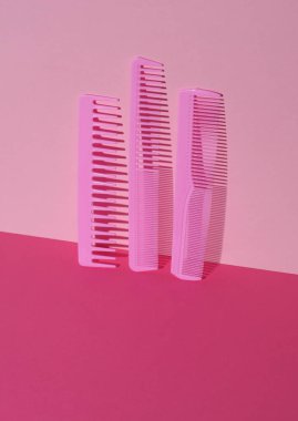 Pembe arka planda plastik taraklar. Güzellik konsepti. Yaratıcı düzen. Minimalizm