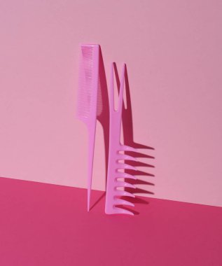 Pembe arka planda plastik taraklar. Güzellik konsepti. Yaratıcı düzen. Minimalizm