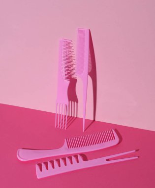 Pembe arka planda plastik taraklar. Güzellik konsepti. Yaratıcı düzen. Minimalizm