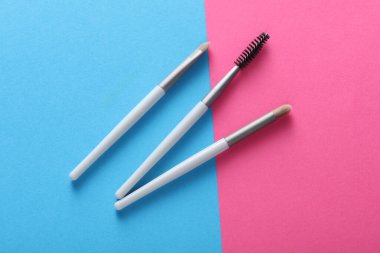 Set of makeup brushes on pink blue background