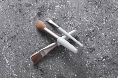 Makeup brushes on concrete background. Top view