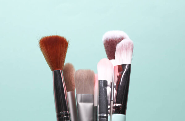 Set of makeup brushes on a blue background
