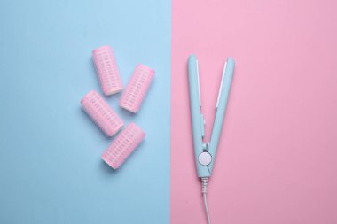 Mavi arka planda plastik bigudiler ve saç düzleştirici. Düz yatıyordu