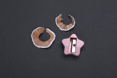 Koyu gri arka planda kalemtıraşlı kalem talaşları