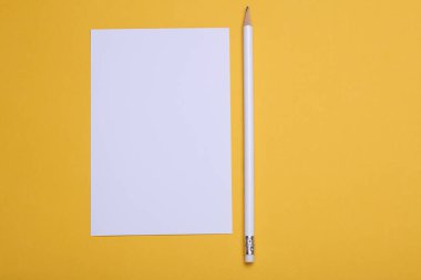 Sarı zemin üzerinde kalem olan beyaz boş kart