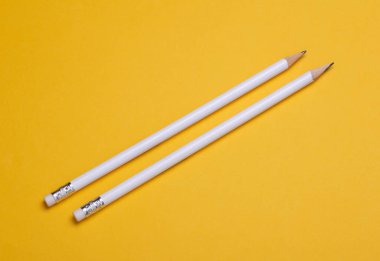 Sarı arka planda silgisi olan beyaz tahta kalemler. Tasarım için model