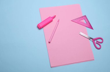 Mavi arka planda okul kağıtları olan pembe kağıtlar. Monokrom fotoğrafçılık. Düz yatıyordu