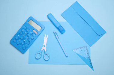 Mavi arka planda okul kağıtları olan mavi kağıtlar. Monokrom fotoğrafçılık. Düz yatıyordu. Yaratıcı yerleşim