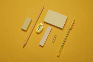 Sarı arka planda okul kırtasiyesi. Monokrom fotoğrafçılık. Düz yatıyordu. Yaratıcı yerleşim