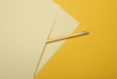 Sarı zemin üzerinde kalem olan kağıt sayfaları