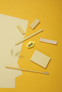 Sarı arka planda okul kağıtları olan kağıtlar. Monokrom fotoğrafçılık. Düz yatıyordu. Yaratıcı yerleşim