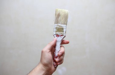 Erkek el fırçayı arka planda tutuyor. Ev yenileme konsepti