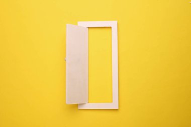 Minyatür açık ahşap kapı sarı arka planda