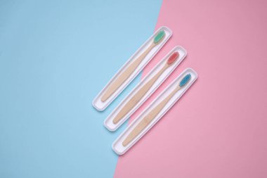 Mavi arka planda ahşap diş fırçası olan plastik kutular.