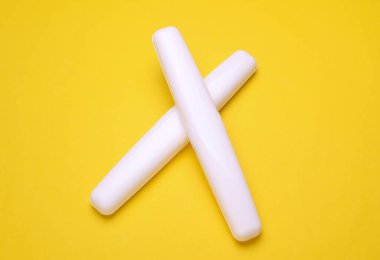 Sarı arka planda diş fırçası olan plastik kutular.