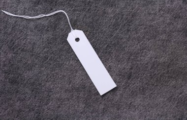 Koyu renk kot pantolon arka planında beyaz kağıt etiket