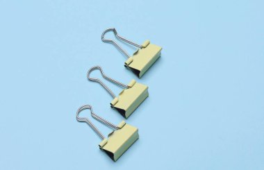 Mavi arkaplanda sarı metal kağıt klasörler.