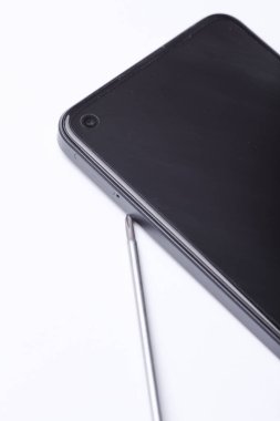 Telefon tamiratı, bakım servisi. Beyaz arka planda tornavidalı akıllı telefon