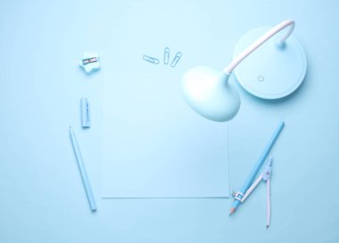 Mavi Kırtasiye seti açık mavi arkaplanda. Okula, eğitime, ofis malzemelerine. Tek renkli bir fotoğraf. Düz yatıyordu. Üst Manzara. Yaratıcı yerleşim