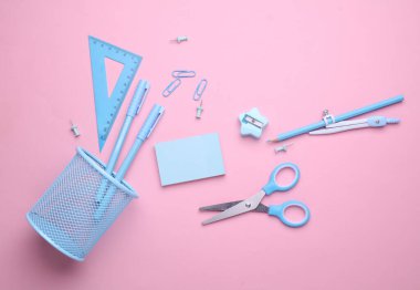 Pembe pastel arka planda mavi kırtasiye seti. Okula, eğitime, ofis malzemelerine. Düz yatıyordu. Üst Manzara. Yaratıcı yerleşim