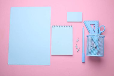 Pembe pastel arka planda mavi kırtasiye seti. Okula, eğitime, ofis malzemelerine. Düz yatıyordu. Üst Manzara. Yaratıcı yerleşim