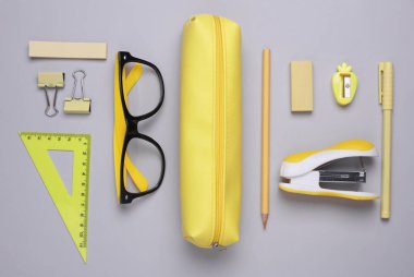 Gri arka planda kırtasiye malzemesi olan sarı kalem kutusu. Düz yatıyordu