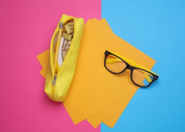 Pembe arka planda kırtasiye malzemesi olan sarı kalem kutusu. Düz yatıyordu