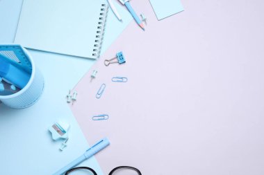 Mavi kırtasiye seti ve gri arka planda kağıt kağıtlar. Okula, eğitime, ofis malzemelerine. Düz yatıyordu. Üst Manzara. Yaratıcı yerleşim