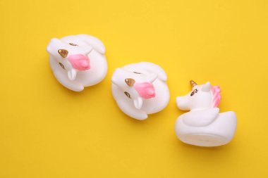 Sarı arka planda lastik banyo tek boynuzlu atları. Üst Manzara. Yaratıcı yerleşim