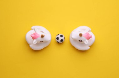 Sarı arka planda futbol topu olan lastik küvetli tek boynuzlu atlar. Üst Manzara. Spor konsepti