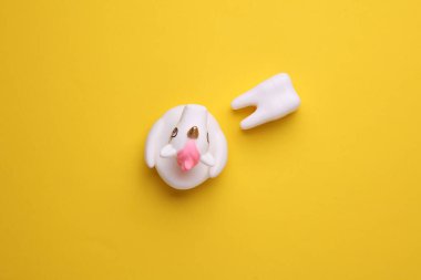 Sarı arka planda dişleri olan lastik tek boynuzlu at.