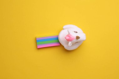 Sarı arka planda gökkuşağı olan lastik tek boynuzlu at. Yaratıcı fikir