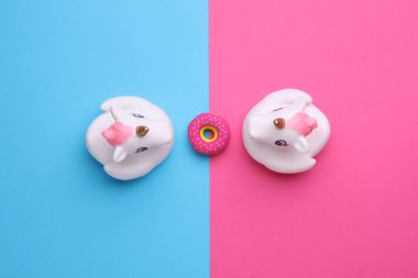 Kauçuk banyo tek boynuzlu atları pembe mavi arka planda donut ile. Üst görünüm.