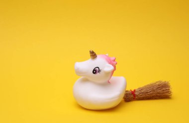 Sarı arka planda cadılar bayramı dekoru olan lastik banyo tek boynuzlu atı. Üst görünüm.