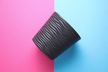 Mavi arka planda siyah çiçek saksısı